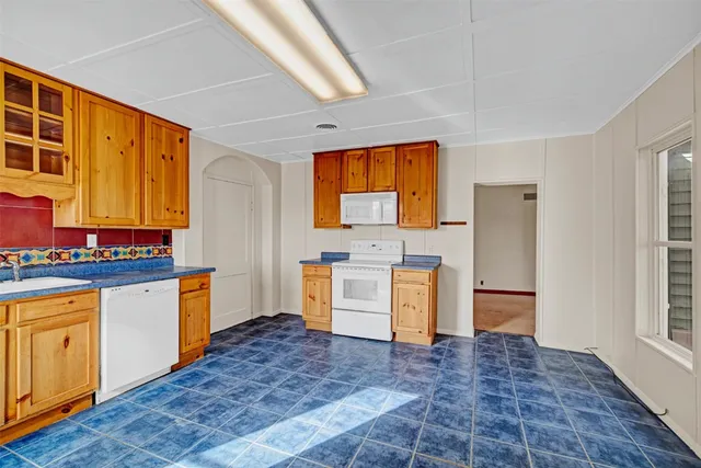 a kitchen with granite countertop a sink cabinets stainless steel appliances and a window