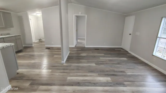 an empty room with wooden floor and a fireplace