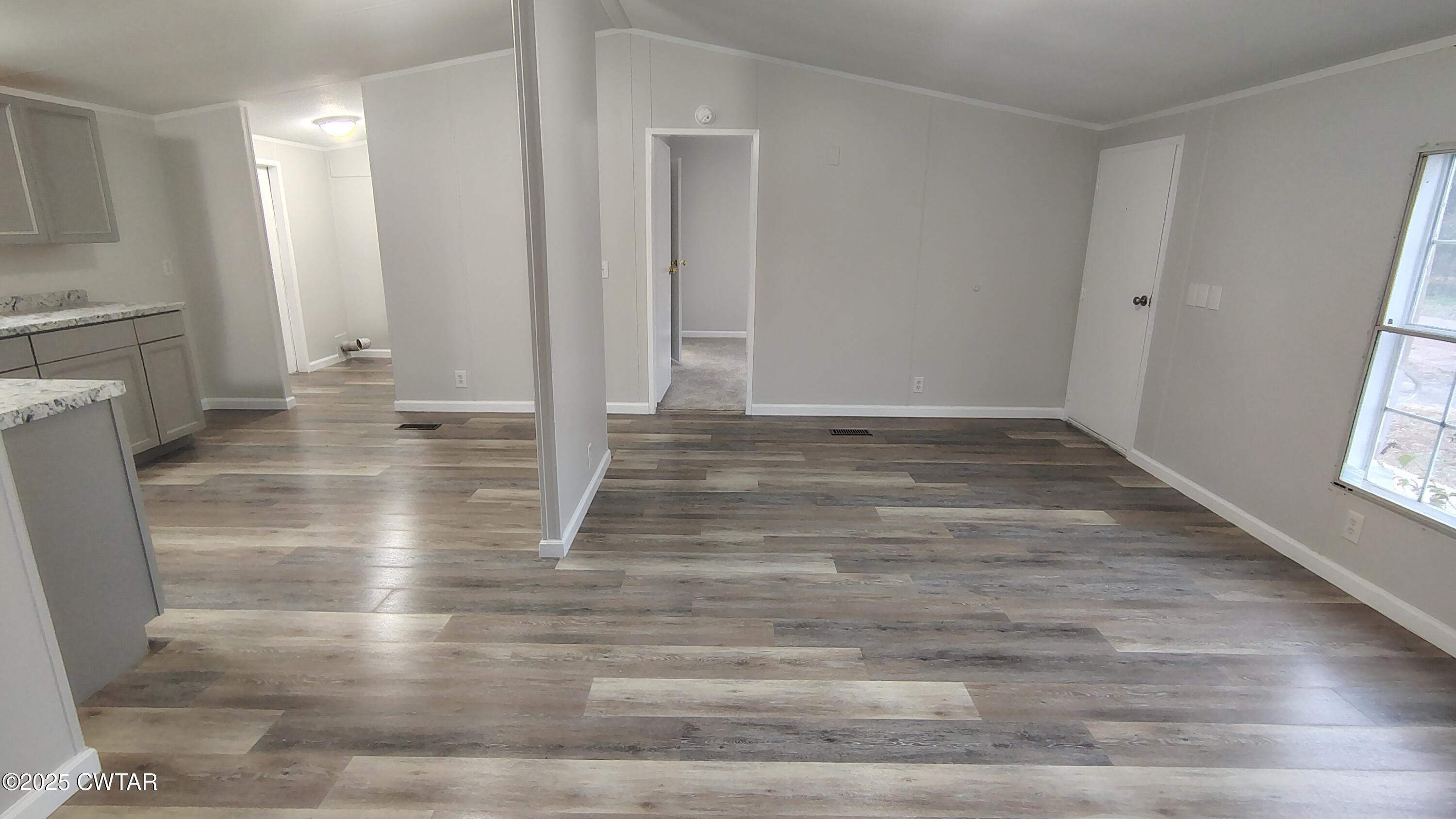 420 South Main Street Ridgely, TN 38080 - Photo 2 of 13 an empty room with wooden floor and a fireplace