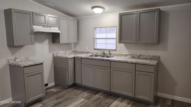 a kitchen with stainless steel appliances granite countertop a sink stove and cabinets