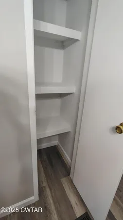 a view of walk in closet with empty racks