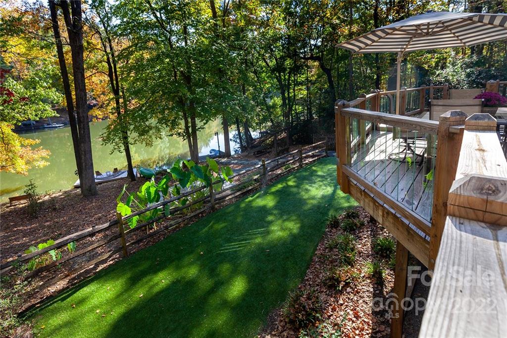 4301 Eagle Lake Drive Charlotte, NC 28217 - Photo 36 of 41 a view of a deck with a table and chairs under an umbrella with wooden fence
