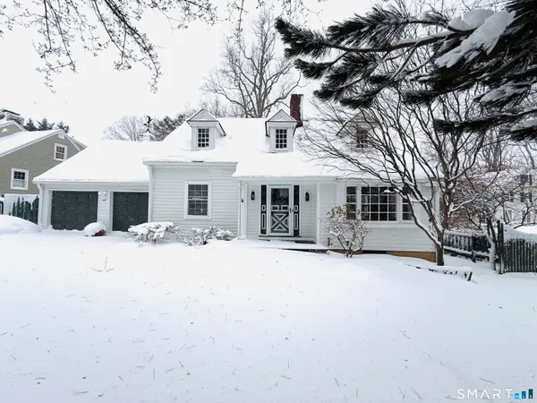 a front view of a house with a yard covered in snow