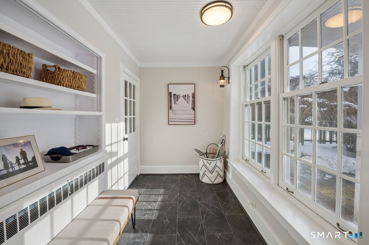 1091 Round Hill Road Fairfield, CT 06824 - Photo 18 of 28 a view of a hallway to room with wooden floor and windows