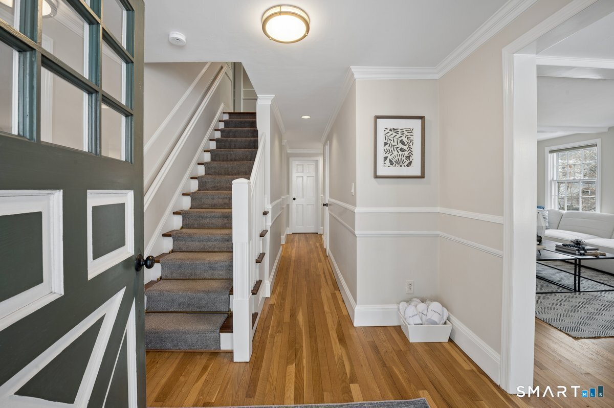 1091 Round Hill Road Fairfield, CT 06824 - Photo 9 of 28 a view of a hallway with wooden floor and staircase