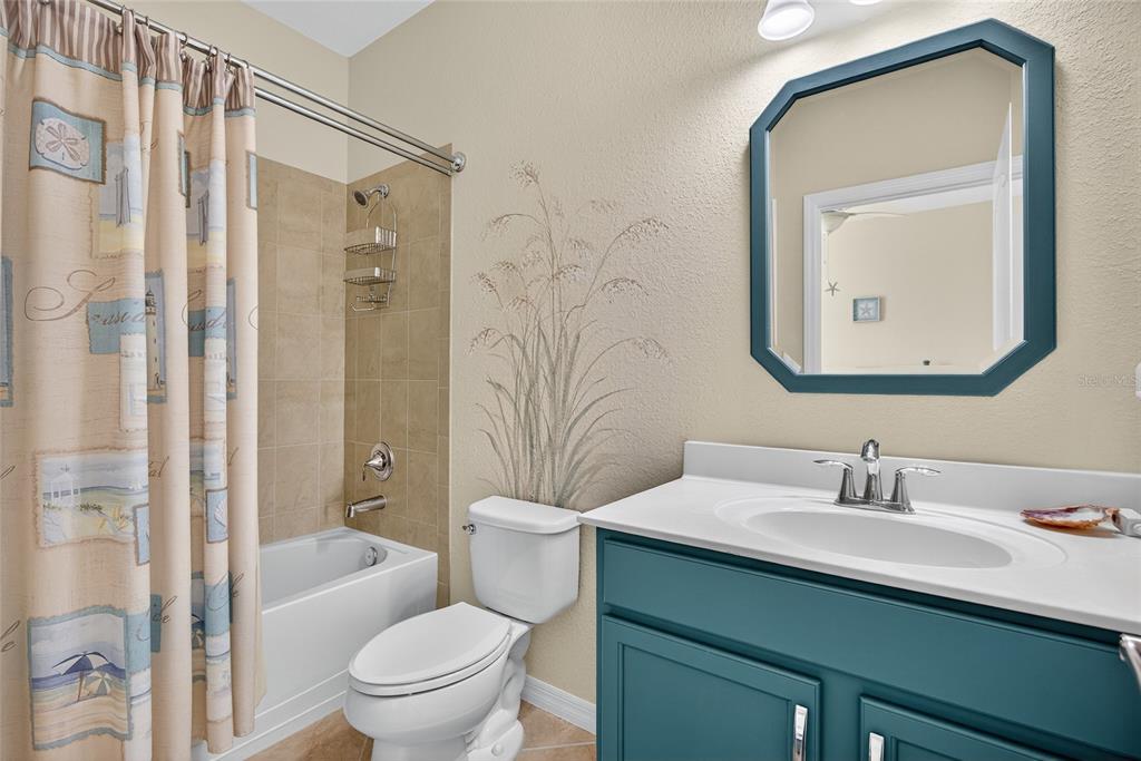 2877 Via Piazza Loop Fort Myers, FL 33905 - Photo 21 of 39 a bathroom with a toilet a sink a tub and a mirror