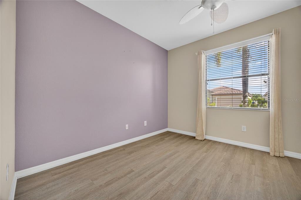 2877 Via Piazza Loop Fort Myers, FL 33905 - Photo 22 of 39 an empty room with wooden floor and windows