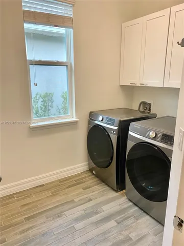 a storage room with wooden floor washer and dryer