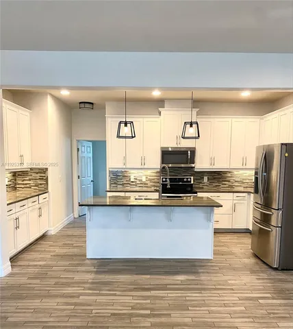 a kitchen with stainless steel appliances granite countertop a stove a sink and a refrigerator