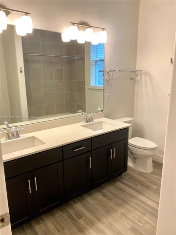 a spacious bathroom with a double vanity sink toilet and a mirror