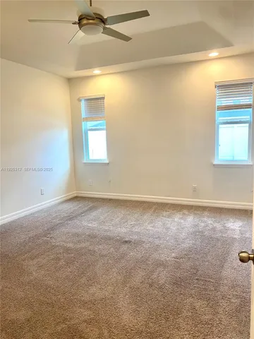 an empty room with a window and a ceiling fan