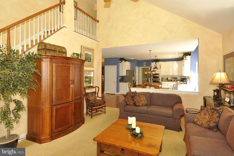 a living room with furniture a refrigerator and a dining table with wooden floor