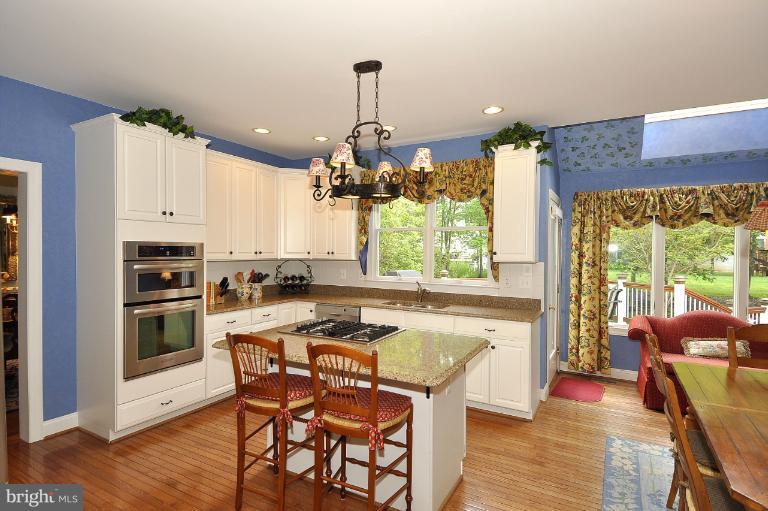 115 Fox Trail Terrace Gaithersburg, MD 20878 - Photo 21 of 22 a kitchen with a table chairs stove and cabinets