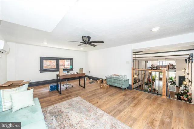 a view of a hallway with wooden floor and a bathroom