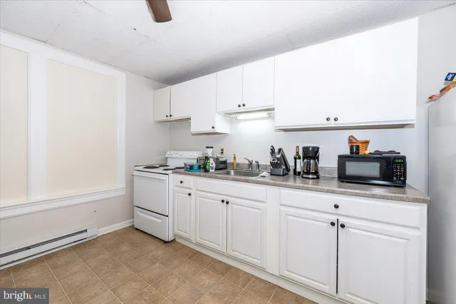 a bathroom with a sink vanity mirror and bathtub