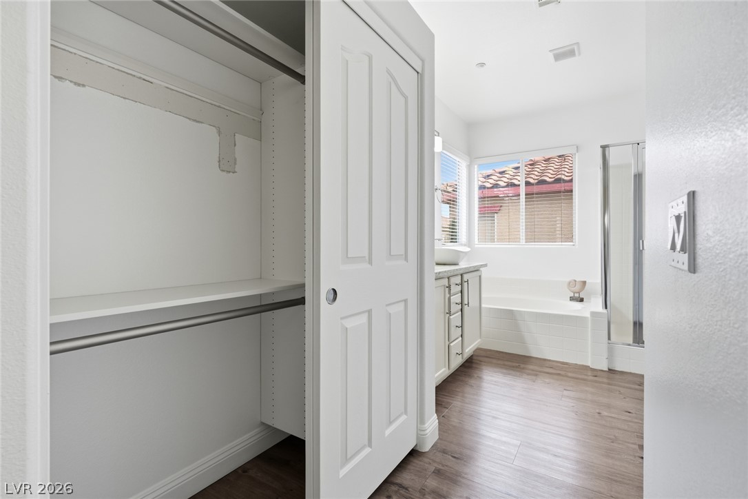 8932 Caledon Ridge Court Las Vegas, NV 89149 - Photo 27 of 39 Gleaming wood flooring complements the bright vanity and built-in closet storage in this spacious bathroom.