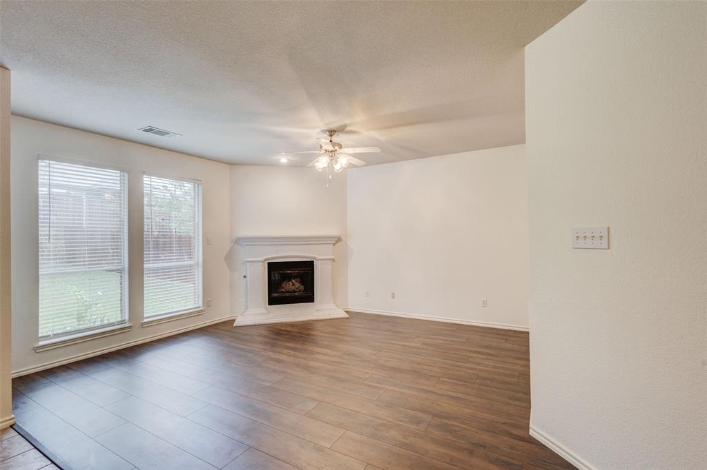 7048 Summit Parc Drive Dallas, TX 75249 - Photo 11 of 20 an empty room with wooden floor fireplace and windows