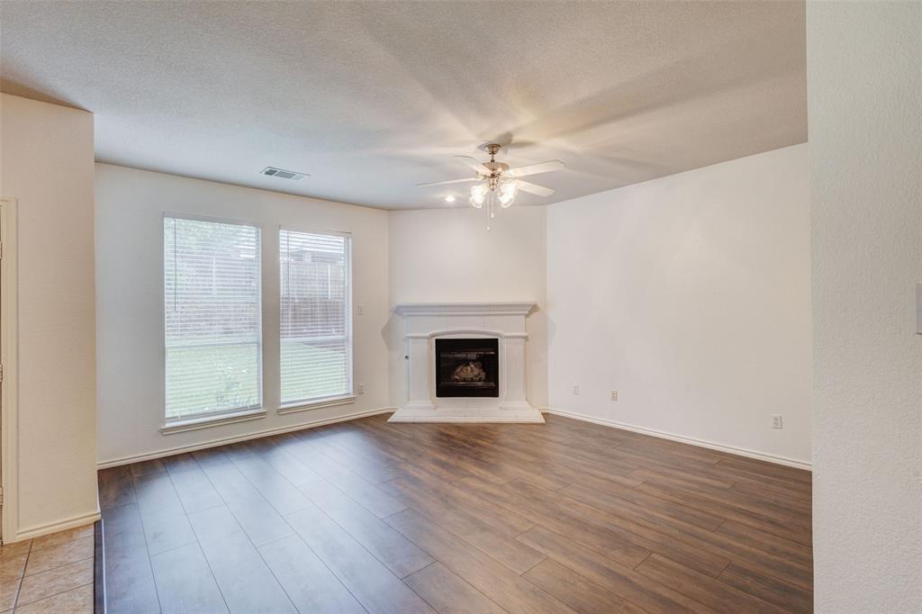 7048 Summit Parc Drive Dallas, TX 75249 - Photo 12 of 20 an empty room with wooden floor fireplace and windows