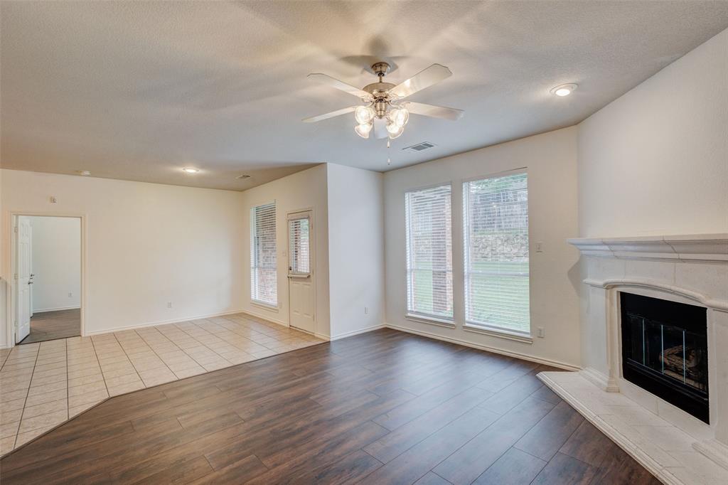 7048 Summit Parc Drive Dallas, TX 75249 - Photo 13 of 20 a view of an empty room with wooden floor fireplace and a window