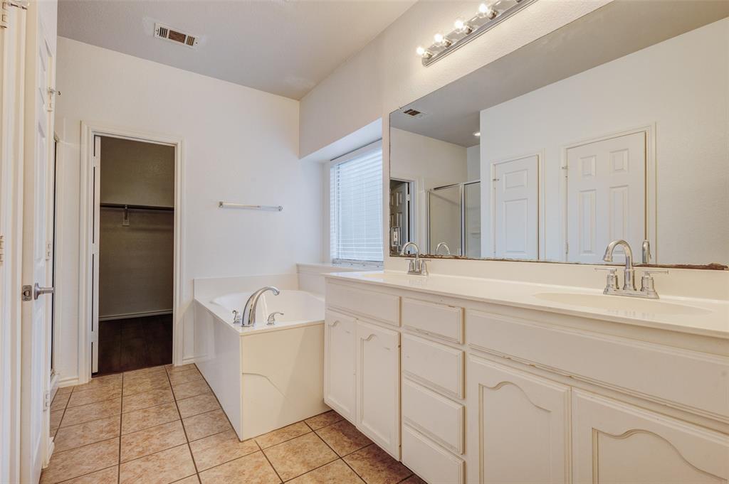 7048 Summit Parc Drive Dallas, TX 75249 - Photo 16 of 20 a spacious bathroom with a sink a mirror and bathtub