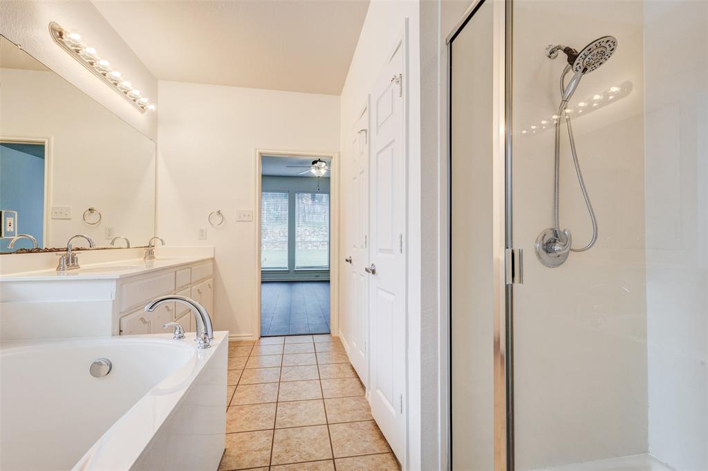 7048 Summit Parc Drive Dallas, TX 75249 - Photo 17 of 20 a bathroom with a bathtub a sink a mirror and a shower
