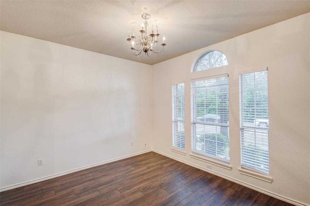 7048 Summit Parc Drive Dallas, TX 75249 - Photo 4 of 20 a view of an empty room with wooden floor and a window