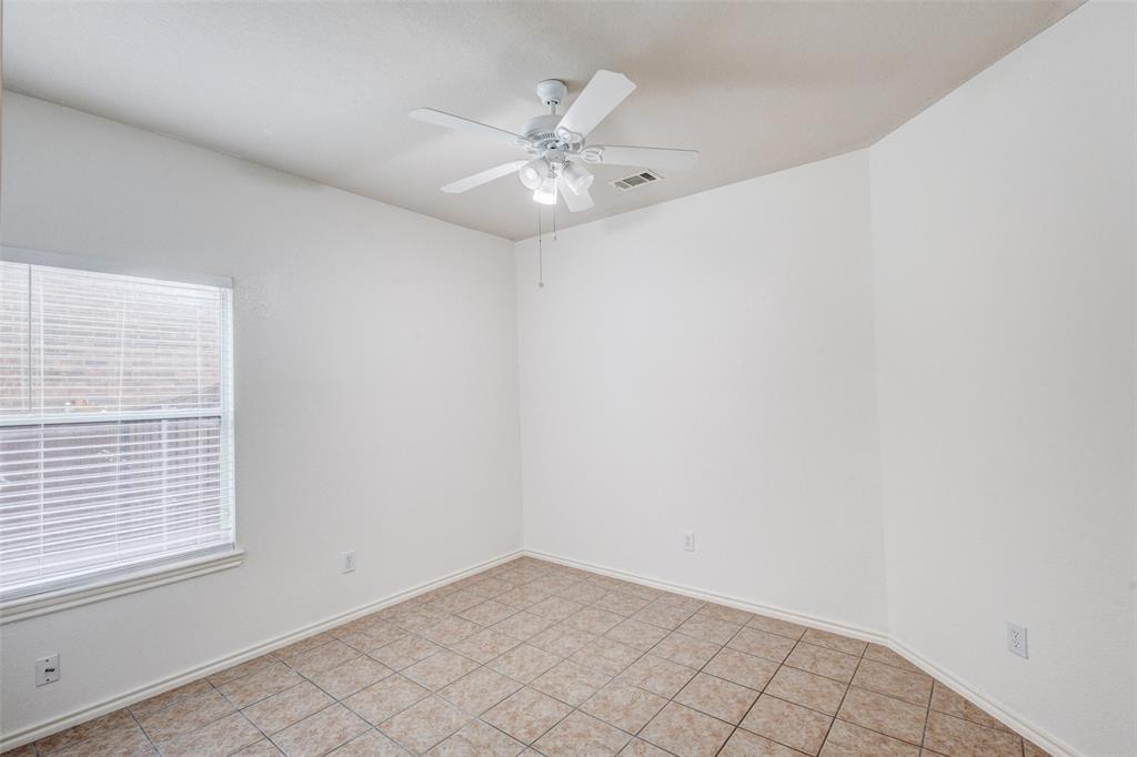 7048 Summit Parc Drive Dallas, TX 75249 - Photo 5 of 20 an empty room with a window and a fan