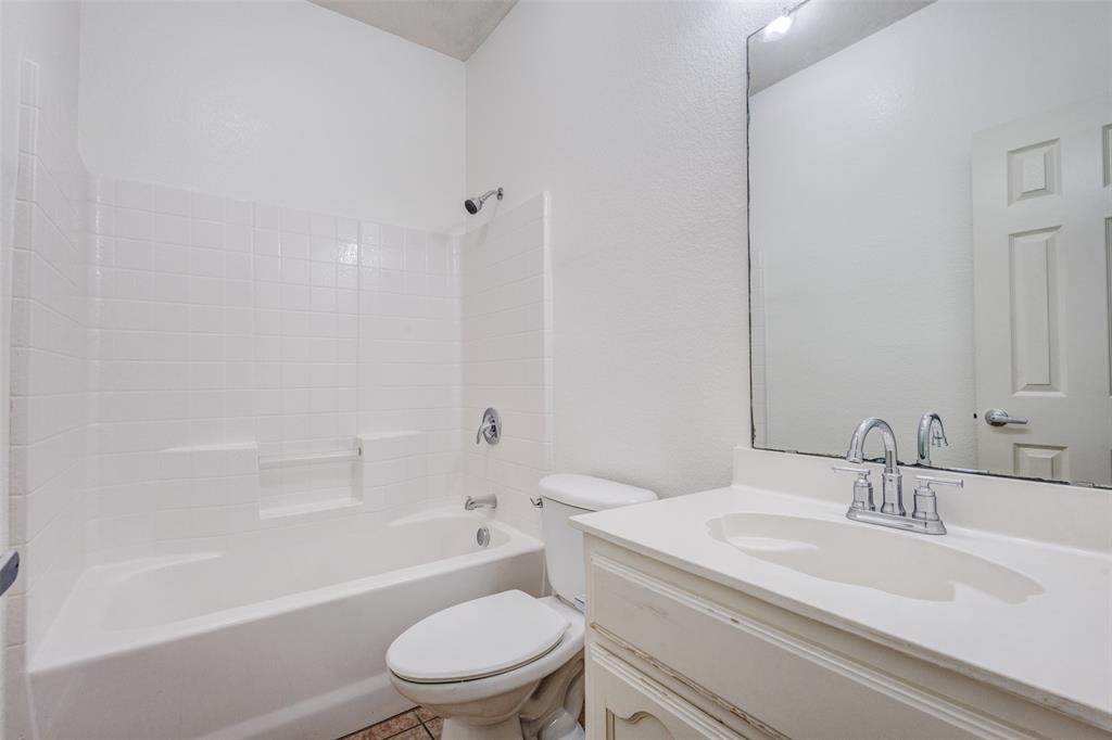 7048 Summit Parc Drive Dallas, TX 75249 - Photo 7 of 20 a bathroom with a granite countertop toilet a sink and a bathtub