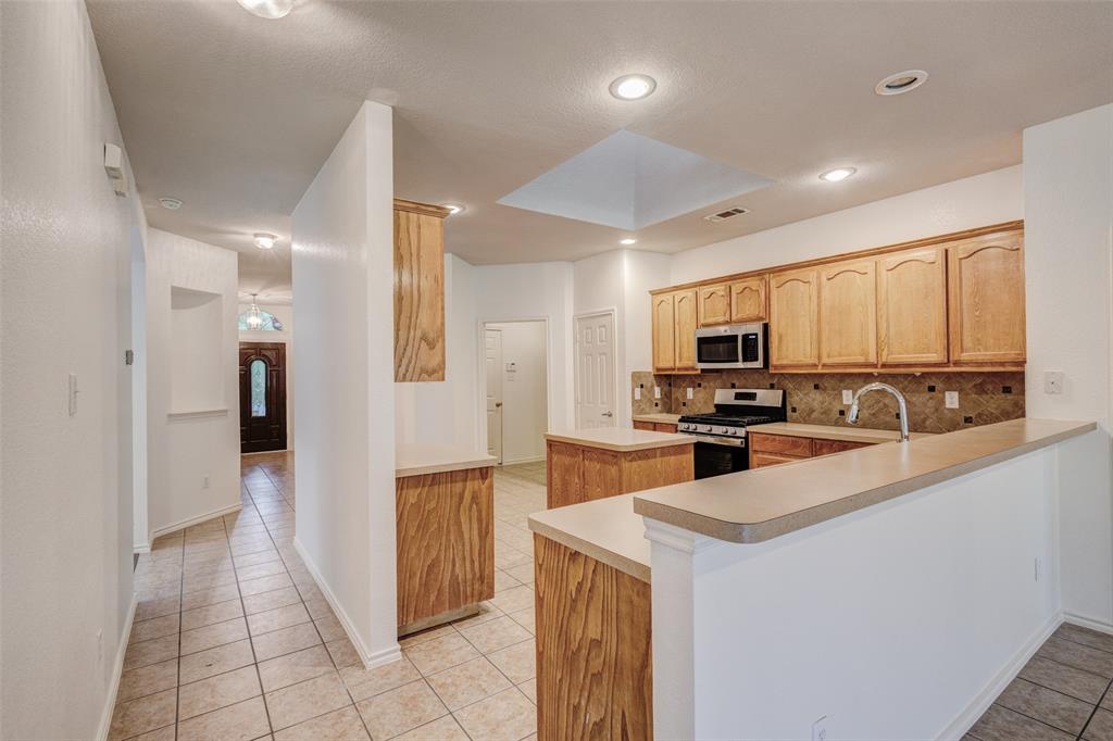 7048 Summit Parc Drive Dallas, TX 75249 - Photo 8 of 20 a large kitchen with a large counter top appliances and cabinets
