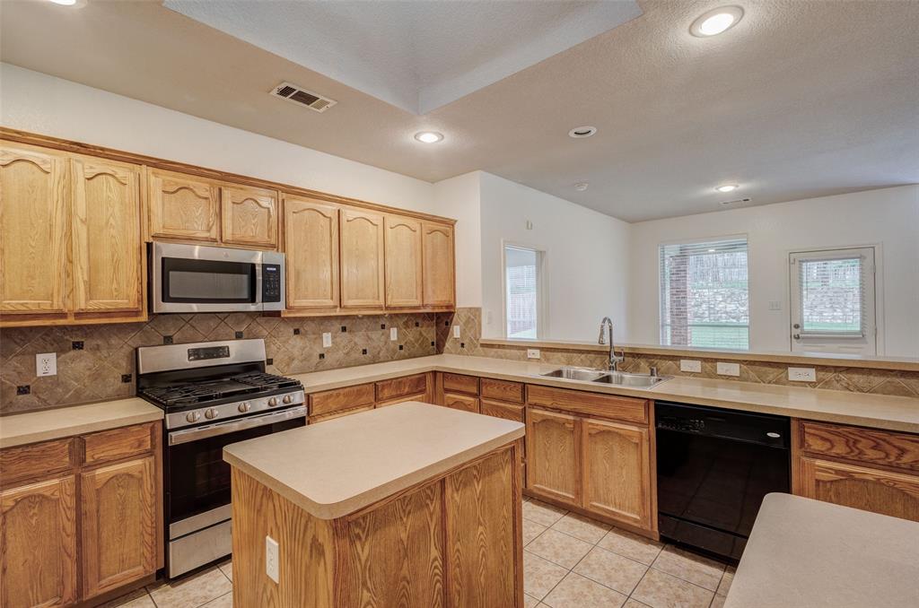 7048 Summit Parc Drive Dallas, TX 75249 - Photo 10 of 20 a kitchen with a sink stove and microwave