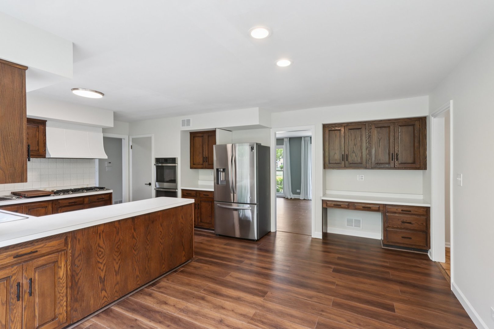 6527 Maple Street Morton Grove, IL 60053 - Photo 11 of 35 a large kitchen with stainless steel appliances a refrigerator and a stove top oven