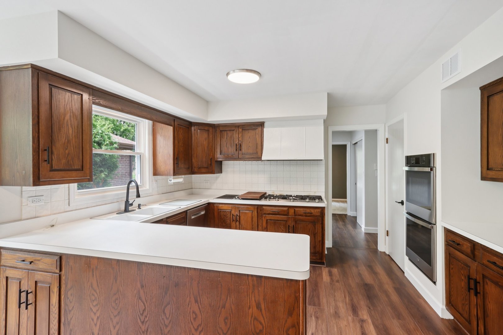 6527 Maple Street Morton Grove, IL 60053 - Photo 9 of 35 a kitchen with stainless steel appliances granite countertop a sink stove and refrigerator