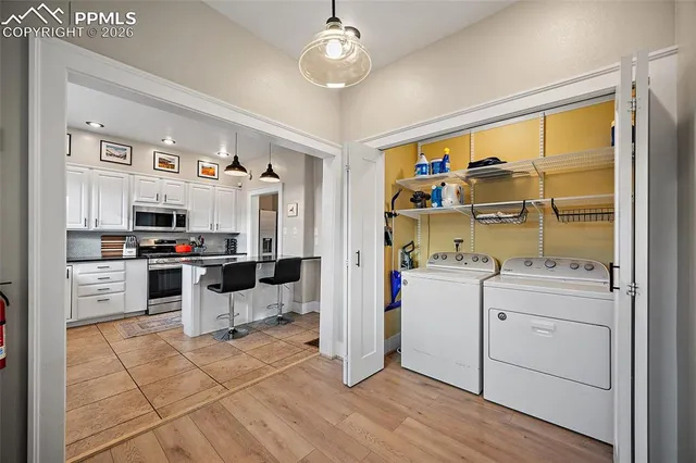 a kitchen with stainless steel appliances kitchen island granite countertop a stove and white cabinets