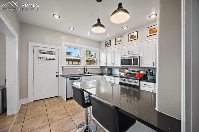a kitchen with stainless steel appliances a stove refrigerator sink and microwave