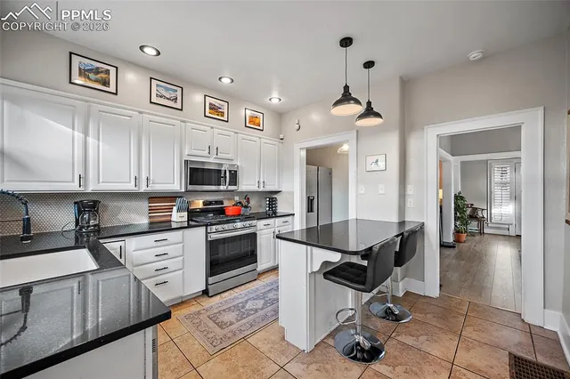 a kitchen with granite countertop a sink appliances and cabinets