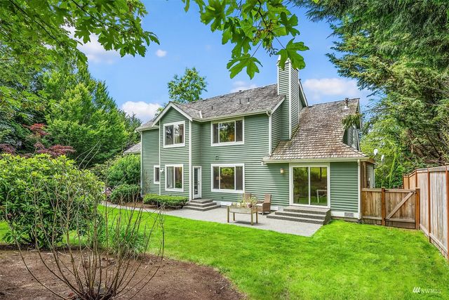 a front view of a house with a yard and green space