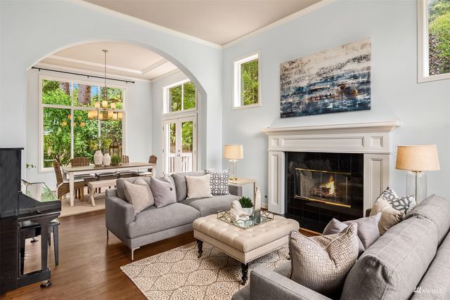 a living room with furniture a large window and a fireplace