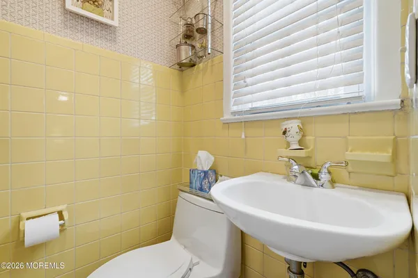 a bathroom with a sink a toilet and a mirror