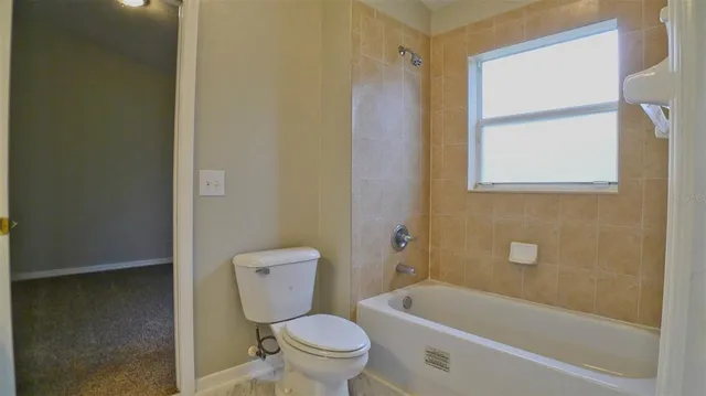 a white toilet sitting next to a bath tub
