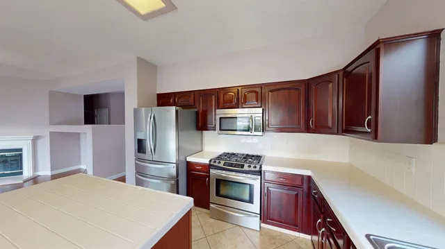 a kitchen with stainless steel appliances a stove microwave and refrigerator