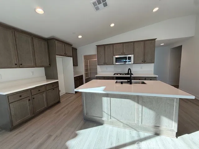 a kitchen with kitchen island a stove a sink and a refrigerator