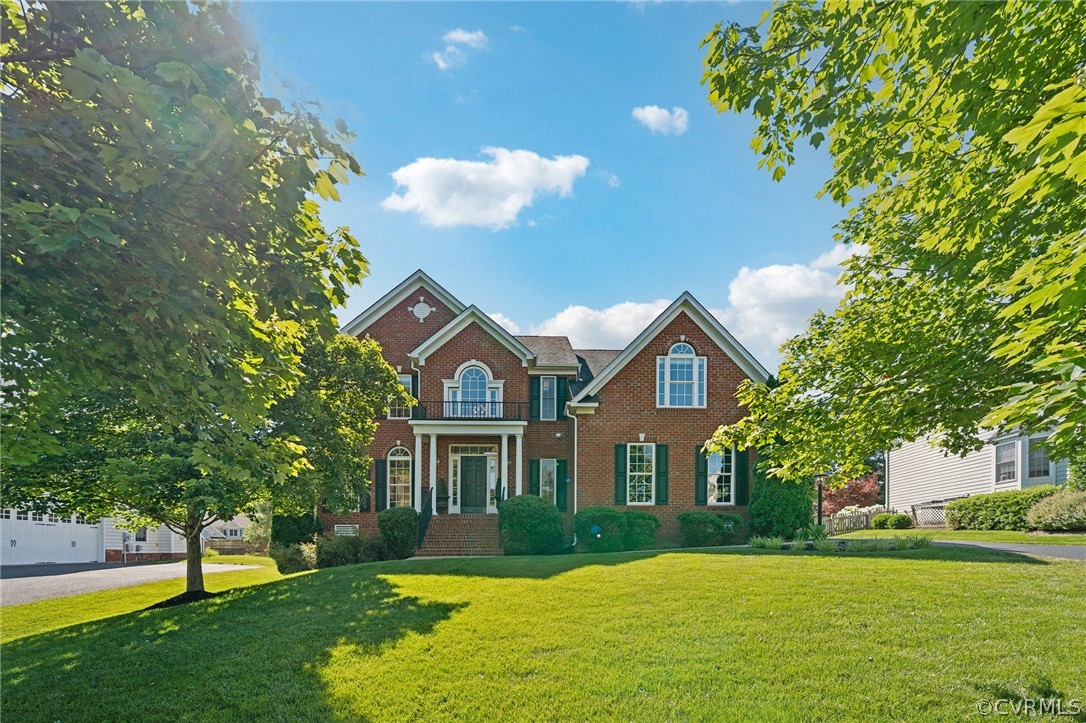 a front view of a house with a yard and trees