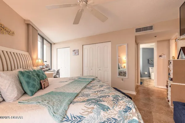 a bedroom with a bed and a large window with outer view