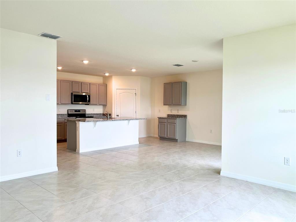 2877 Sunridge Loop St. Cloud, FL 34771 - Photo 4 of 19 a view of kitchen with kitchen island a sink stainless steel appliances and cabinets