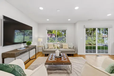 a living room with furniture a large window and a flat screen tv