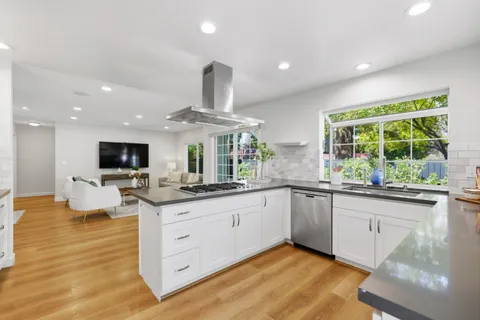 a kitchen with granite countertop a sink and a stove top oven