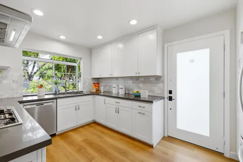 a kitchen with granite countertop white cabinets and white appliances