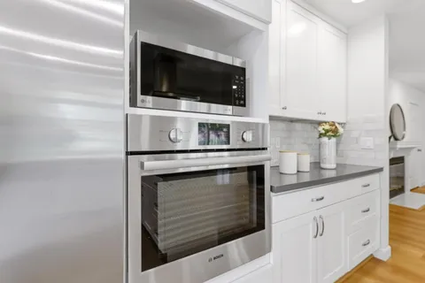 a room with a sink and mirror with window