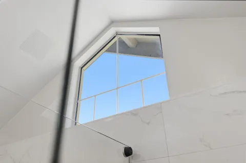 a bedroom with a bed table flowerpot and window