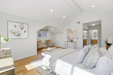 a bedroom with a bed and painting on the wall